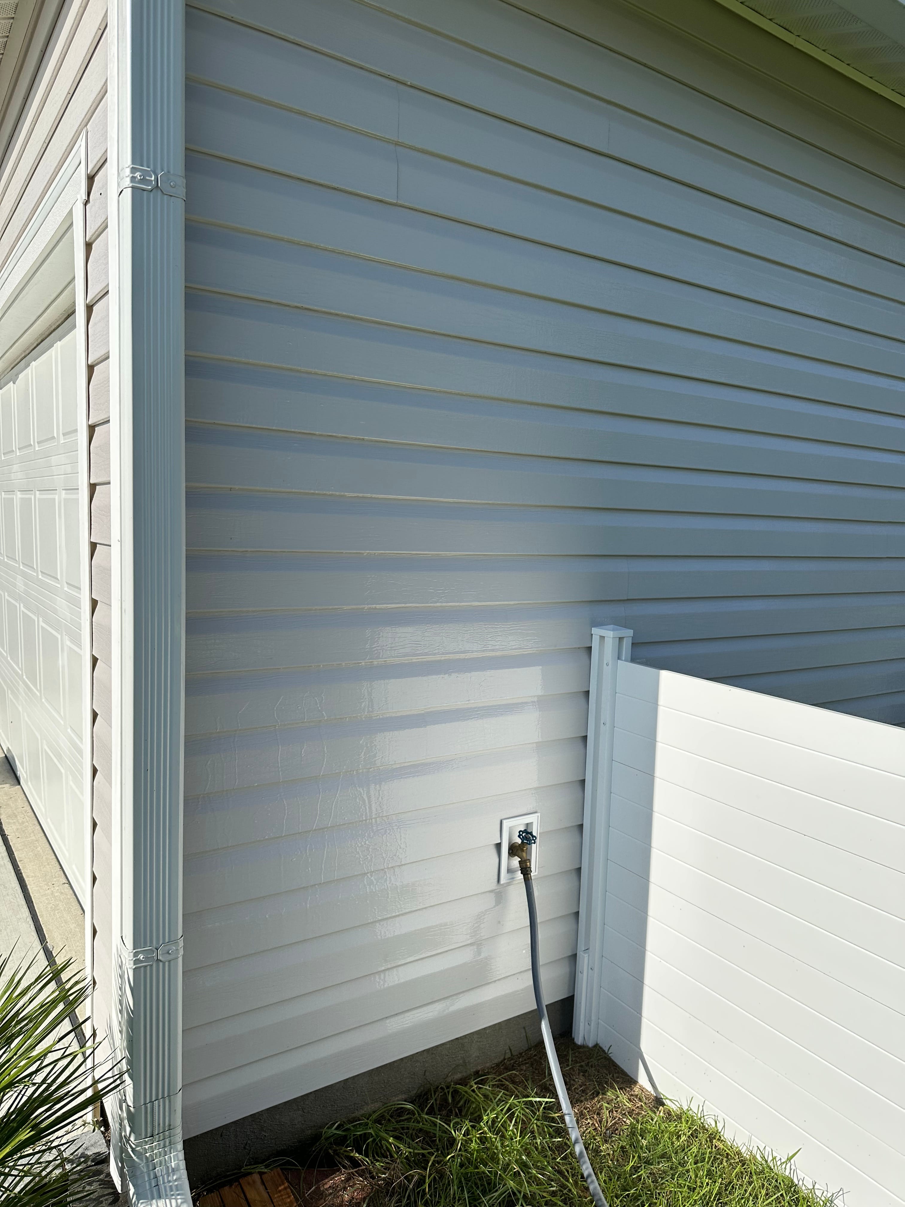 Home exterior during a soft wash and pressure washing job